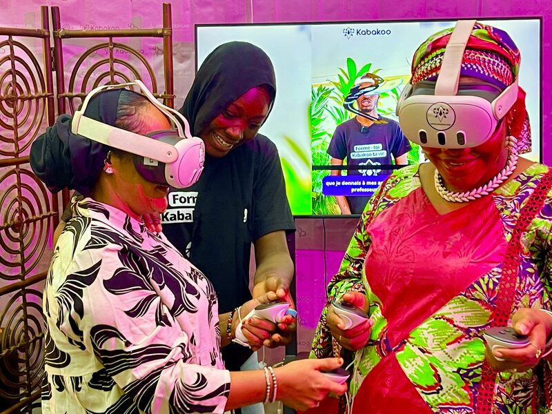 Three women, two wearing VR headsets, laugh together at the Kabakoo stand during SENUMA.